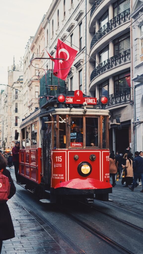 red tram on the street during daytime